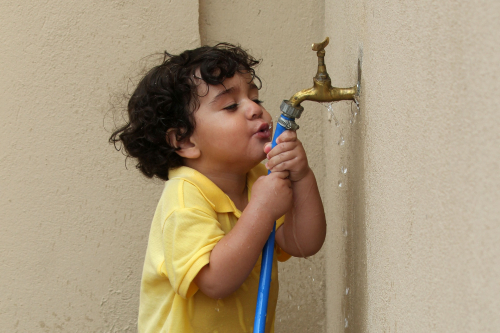 Kid playing hose tap